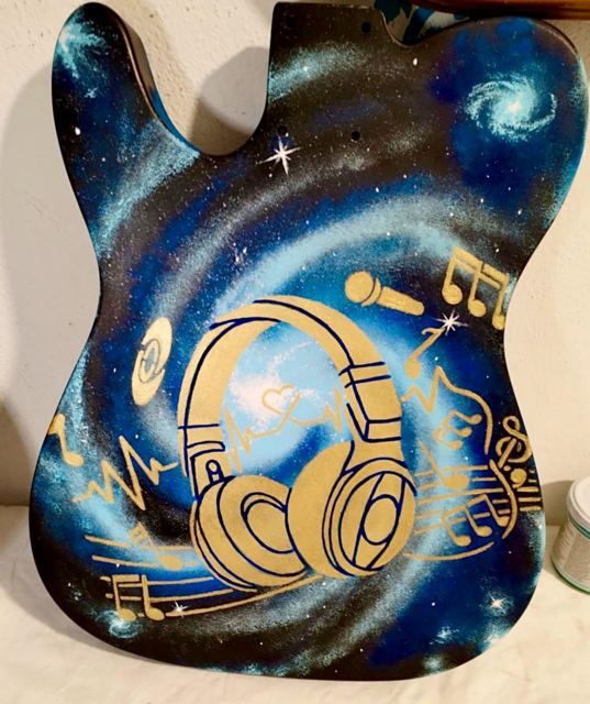 Corpo di chitarra con galassia e cuffie dorate