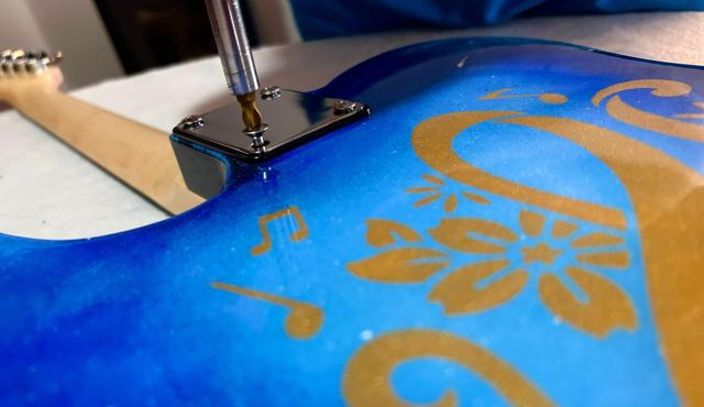 Primo piano di decori dorati con fiori e note su fondo blu