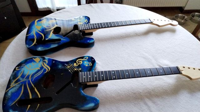 Due corpi di chitarra dipinti blu e oro con il manico