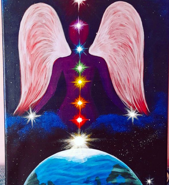 Figura alata con i chakra luminosi sopra la Terra