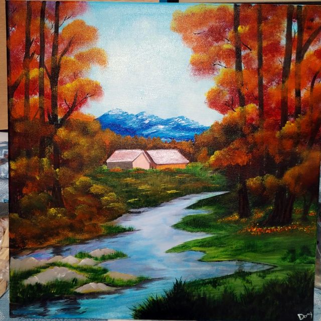 Bosco autunnale con fiume e montagne innevate