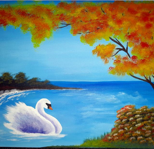 Cigno bianco su un lago azzurro con alberi d'autunno