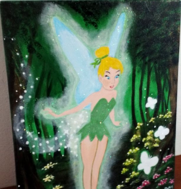 Fatina con l'abito verde tra alberi scuri e fiori bianchi