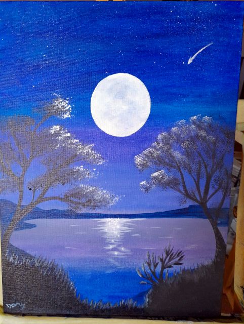 Luna piena sopra un lago di notte tra gli alberi