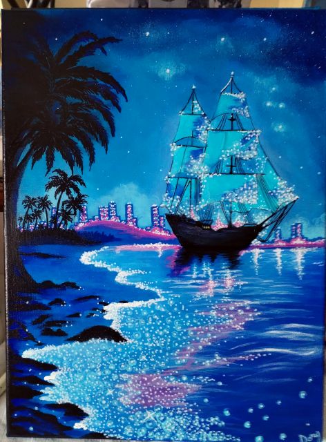 Velero iluminado en una bahía tropical de noche, con reflejos azules en el mar